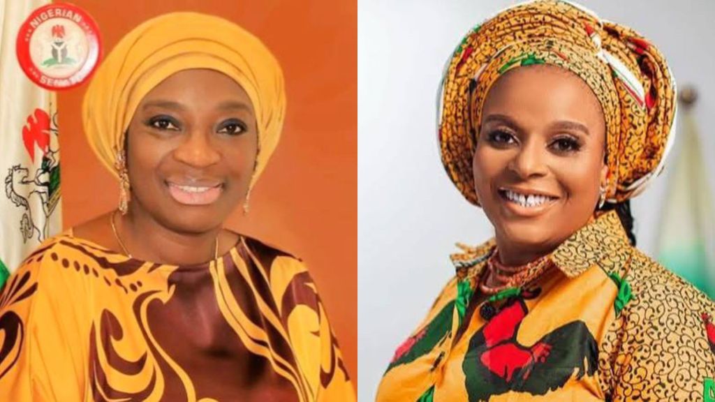 L-R: Senator Uche Ekwunife wearing a yellow headscarf and patterned attire, smiling with a Nigerian Senate emblem behind her. Beside her is Nonye Soludo, wife of Anambra State Governor, dressed in a colourful patterned outfit with a matching headwrap, also smiling.