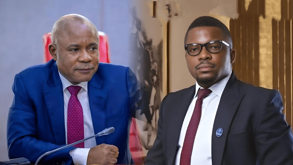 Enugu State Governor Barr. Peter Mbah is seated in an official setting, wearing a navy blue suit with a red tie, while beside him, Sujimoto Group boss Olasijibomi Ogundele poses in a dark suit, glasses, and a red tie, exuding a formal and corporate look.