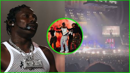 Nigerian singer Portable performing on stage during his “Awake” concert, wearing a white mesh vest with heavy silver chains, alongside backup dancers in camo trousers, with bright stage lights and a cheering crowd in the background