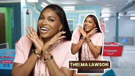 BBNaija Season 10 housemate Thelma Lawson beams with joy in a pink outfit, striking a playful pose with both hands framing her face. Beside her is a cut-out styled graphic of her smiling in the same look, with her name “Thelma Lawson” boldly displayed at the bottom.