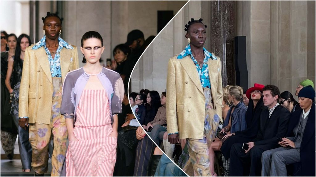 Rapper Blaqbonez walks the runway in a gold jacket, floral pants, and patterned shirt during a Paris fashion show, as audience members watch from the front row.