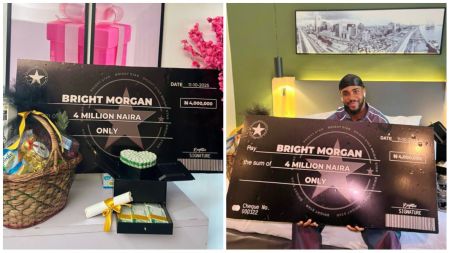 BBNaija star Bright Morgan poses with a large mock cheque of ₦4 million from his fans, alongside gift baskets and cash boxes displayed on a table.
