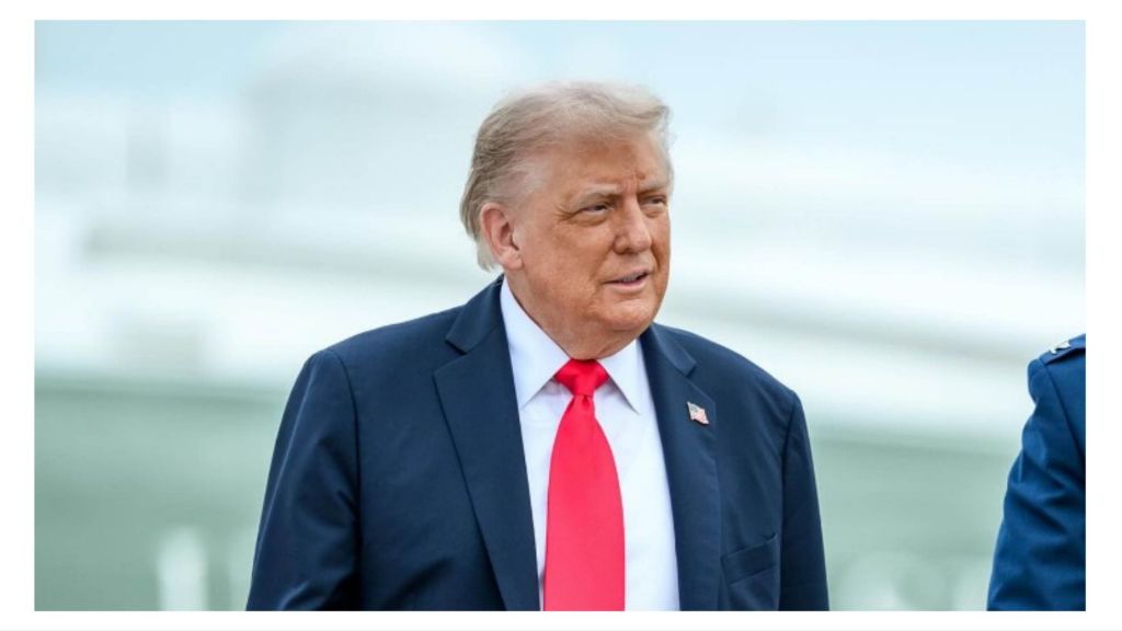 Former U.S. President Donald Trump wearing a navy suit and red tie, standing outdoors with a neutral expression.