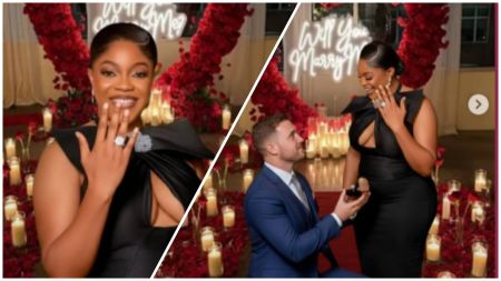 Actress Eve Esin smiles as she shows off her engagement ring while her partner kneels to propose in a romantic setup decorated with red roses, candles, and a glowing “Will You Marry Me?” sign.