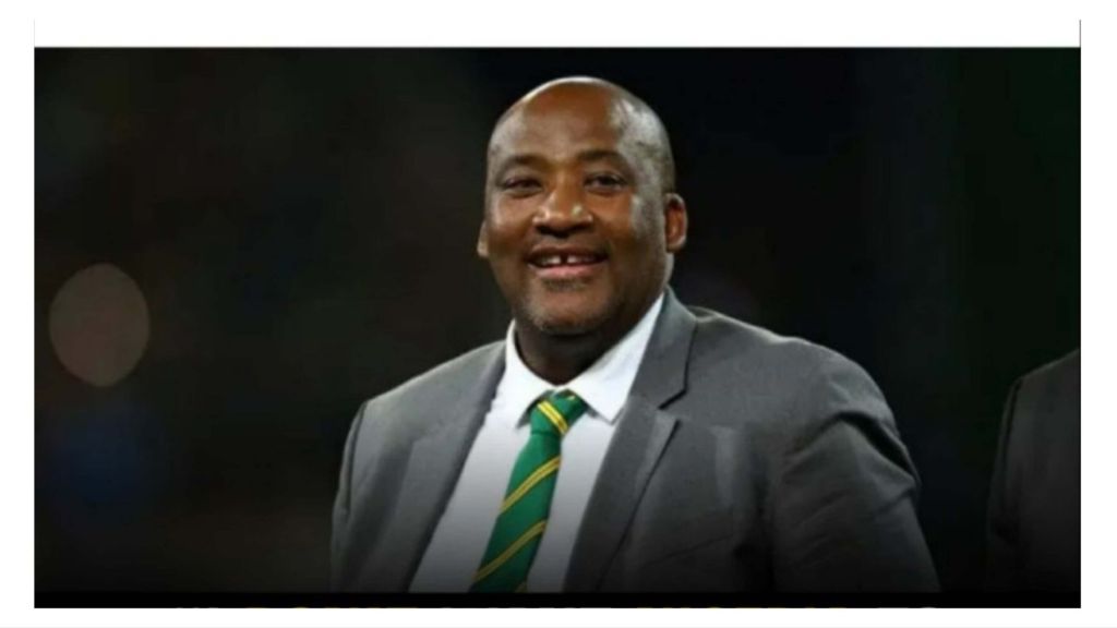 South Africa’s Minister of Sports, Arts, and Culture, Gayton McKenzie, smiles in a grey suit and green-striped tie during a public appearance.