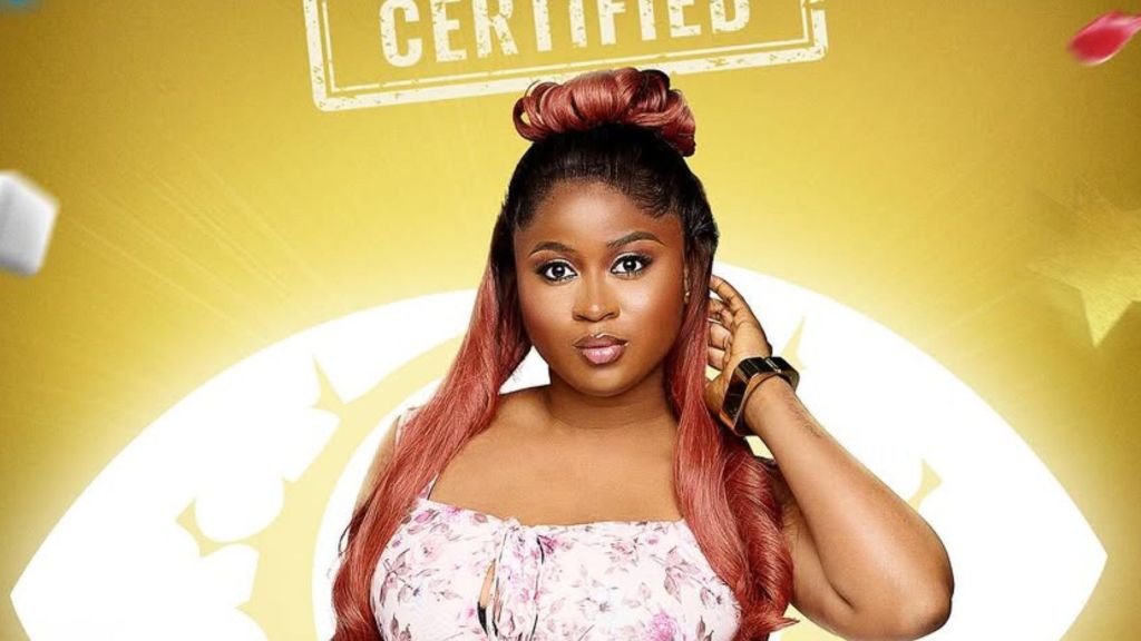 BBNaija Season 10 housemate Imisi poses confidently in her official portrait, wearing a floral dress against a bright yellow background with the word “Certified” displayed above her.