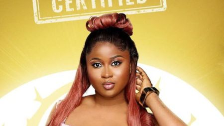 BBNaija Season 10 housemate Imisi poses for her official portrait against a gold background with the “Certified” logo displayed above her.
