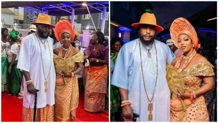 Billionaire businessman Chief Jite Tesigimoje poses with his 19th wife during their traditional wedding ceremony. The couple is dressed in matching peach and white attire adorned with coral beads and gold accessories, surrounded by guests in colourful traditional outfits.
