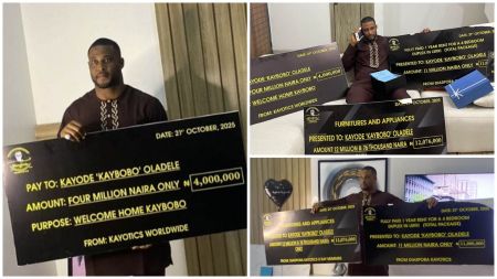 BBNaija Kaybobo holds large mock cheques showing ₦4 million cash gift, ₦11 million rent for a four-bedroom Lekki duplex, and ₦12 million furniture and appliances package from his fan group.