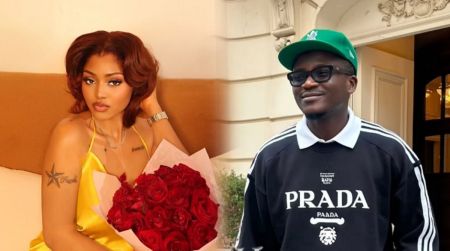 Actress Regina Daniels poses with a bouquet of red roses while singer Portable smiles in a casual Prada sweatshirt and green cap.