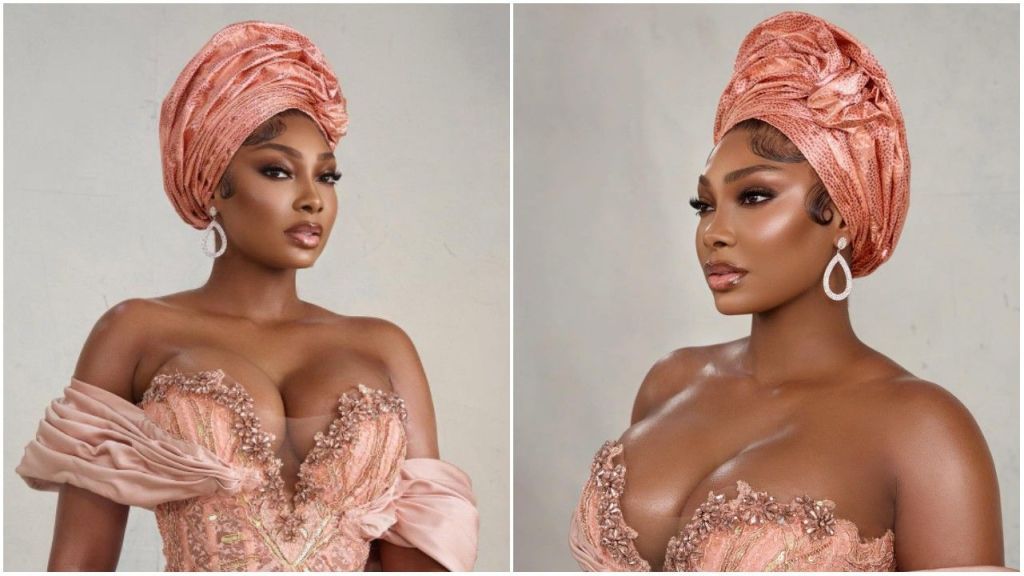 Sophia Egbueje poses in a peach off-shoulder embellished gown with a matching gele, styled with drop earrings, soft glam makeup, and an elegant look in a studio photoshoot.