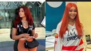 Two photos of influencer Barbiecue placed side by side. In the left image, she is standing outdoors wearing a black cropped top, brown trousers, layered necklaces, and holding a small black bag while looking to the side. In the right image, she is indoors smiling, wearing a long straight red wig and a white-and-red sports-style jersey.