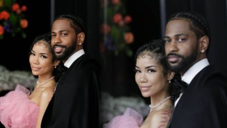Big Sean and Jhené Aiko pose together at a formal event, smiling side by side in elegant outfits.