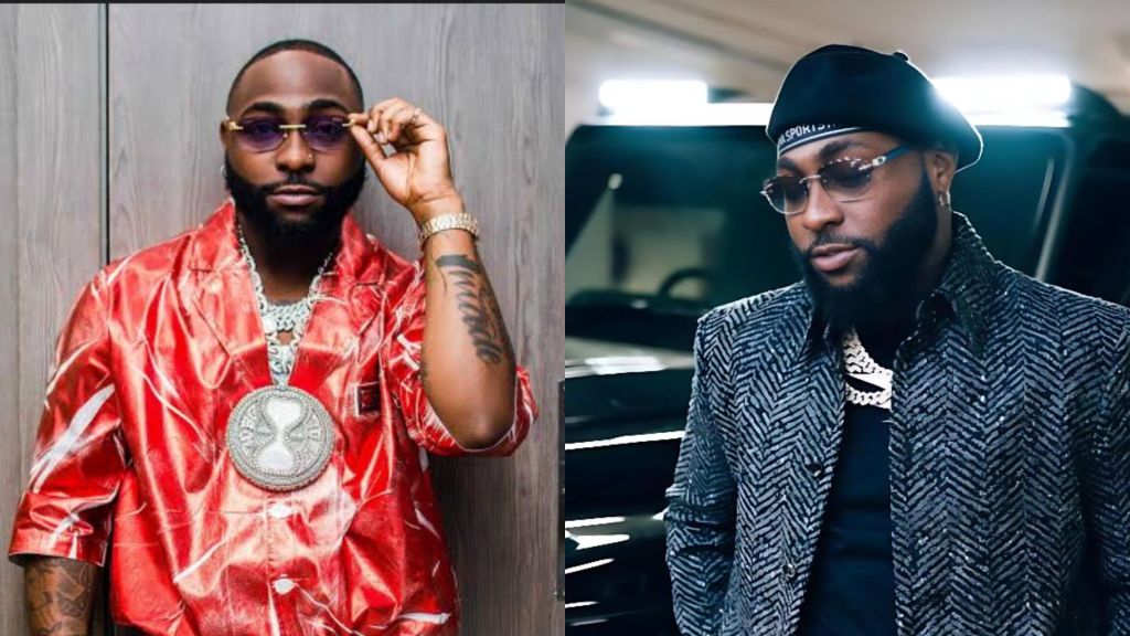 Davido wearing a shiny red outfit and large diamond pendant while adjusting his sunglasses.