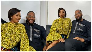 Split-image collage of Big Brother Naija stars and couple Bam Bam (Bamike Olawunmi) and Teddy A (Tope Adenibuyan)—left: both smiling closely together in matching yellow and black traditional Ankara outfits with white embroidery details; right: seated side-by-side in the same coordinated outfits, Bam Bam with legs crossed and Teddy A wearing glasses, against a plain indoor background.