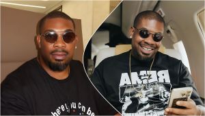 Split-image collage of Nigerian music producer and Mavin Records CEO Don Jazzy aboard a private jet—left: neutral expression wearing round tinted sunglasses, a black T-shirt with partial white text, and a necklace; right: smiling broadly while looking at his phone, wearing similar sunglasses, a black graphic sweatshirt with "REMA" text and gold chains.