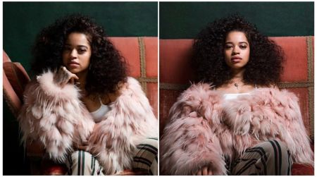 Side-by-side portraits of a woman with voluminous curly hair sitting on a red vintage chair, wearing a fluffy pink fur coat and striped trousers. In the left frame she rests her chin on her hand, and in the right frame she sits upright looking forward.