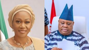 Remi Tinubu defends her conduct after Adeleke stage moment A side-by-side photo showing Nigeria’s First Lady Remi Tinubu on the left, wearing a beige headwrap and light jewellery, and Osun State Governor Ademola Adeleke on the right, dressed in a blue agbada and cap while reading a document.