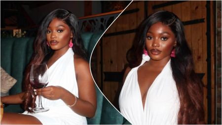 Influencer Raye sits in a dimly lit restaurant wearing a white dress, styled with long wavy hair and pink earrings, holding a wine glass in one image and posing confidently in another.