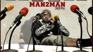Download Instrumental + Hook – Dremo – Man2Man (Open Verse) Dremo sitting at a table surrounded by microphones for the Man2Man single cover art.