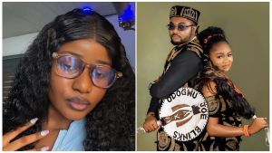 A split image featuring Nigerian lady Everist Patience. On the left, a close-up selfie shows Patience wearing clear-framed glasses and sporting a wavy hairstyle with colorful manicured nails. On the right, Patience and her husband, Jonathan, pose back-to-back in matching black and gold traditional Igbo Isiagu outfits. Jonathan wears a traditional cap and sunglasses while holding a custom "Odogwu Joe Blinks" hand fan, and Patience wears traditional coral beads in her hair and around her neck.